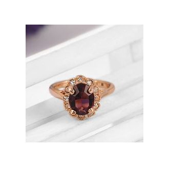   Aranyozott gyűrű, nagy alakú csiszolt bordó-lilás kővel, körülötte apró cirkóniummal