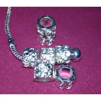   Fém, anyagában mintázott, ezüst színű charm kacskaringó  "S"